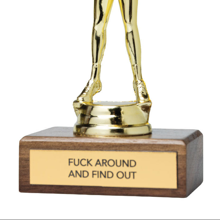 A gold-colored trophy featuring a cheerleader figurine with raised arms, mounted on a rectangular dark brown wooden base with a gold plaque that reads 'FUCK AROUND AND FIND OUT'.