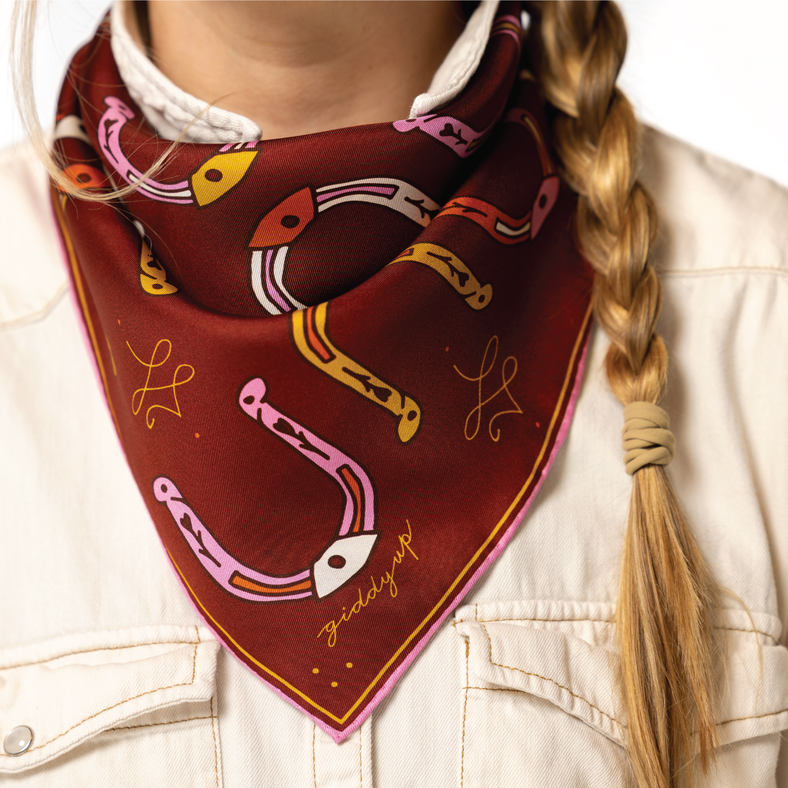 Person wearing a red bandana with horse shoe designs and 'giddy up' text.