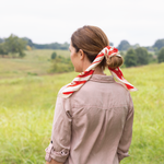 Woman with a red and white striped scarf in a field