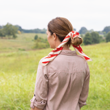 Woman with a red and white striped scarf in a field