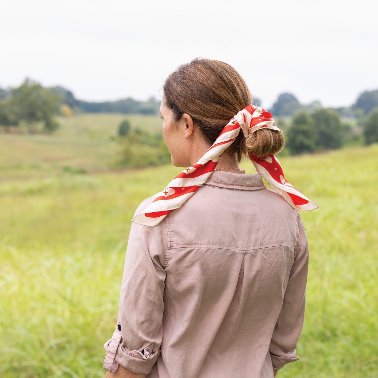 Woman with a red and white striped scarf in a field