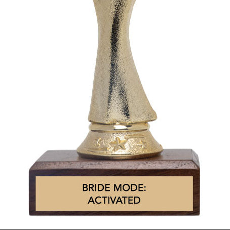 Gold trophy figure with a wooden base with 'bride mode: activated' text.