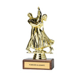 A gold-colored trophy figurine depicting a dancing couple, mounted on a polished dark wood base with a gold plaque engraved with the words 'FOREVER & ALWAYS'.