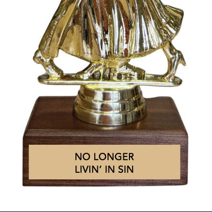 Gold dancing couple trophy with wooden base and engraved text 'no longer livin' in sin' on a white background