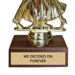 Gold dancing couple trophy with wooden base and engraved text 'we decided on forever' on a white background