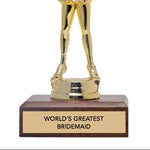 Gold trophy figure of a person in a cheerleading pose with 'world's greatest bridesmaid' text on a wooden base.